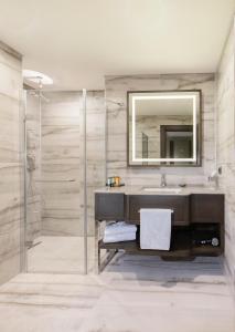 Almira Hotel Thermal Spa & Convention Center في بورصة: حمام مع حوض ومرآة