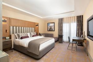 a hotel room with a large bed and a desk at Almira Hotel Thermal Spa & Convention Center in Bursa