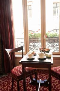 a table topped with a chair next to a window at Hôtel Langlois in Paris
