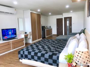 1 dormitorio con 1 cama grande y TV en Chill Chill at Nimman, en Chiang Mai