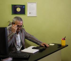 Ein Mann, der auf einem Handy am Schreibtisch sitzt in der Unterkunft U Elzhbety in Lwiw
