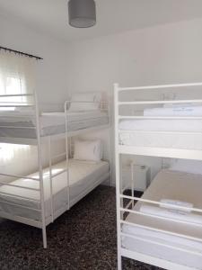イオス島 チョーラにあるGrandma Vasiliki Rooms To Letの白い棚と二段ベッド2台が備わる客室です。