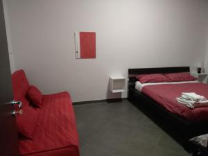 una camera con un letto rosso e una sedia rossa di Caterinette a Bisceglie