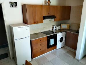 a kitchen with a white refrigerator and a dishwasher at Faneromeni Court in Paphos