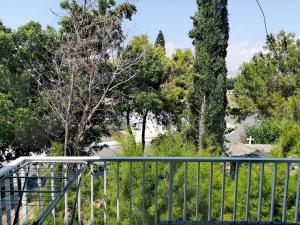 a balcony with a fence and trees and water at Faneromeni Court in Paphos