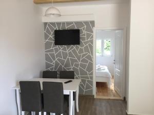 a dining room with a table and a tv on a wall at Guest House Dzakovic Stana in Žabljak
