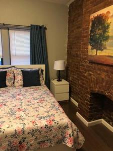 a bedroom with a bed and a brick fireplace at Sandy's Place NYC 1 in Brooklyn