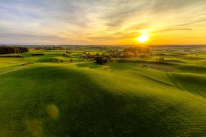 una vista aérea de un campo de golf al atardecer en Boarding & HOUSE T24, en Bad Wurzach