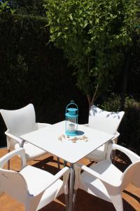 una mesa blanca y sillas con una linterna azul. en Hotel Fernandez, en Sanxenxo