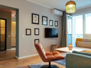 ParkLake Design Apartment - Fabulous View - Netflix في بوخارست: غرفة معيشة مع أريكة وكرسي
