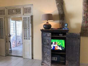 a living room with a tv and a table with a lamp at Villa CECILIA in Oyster Pond