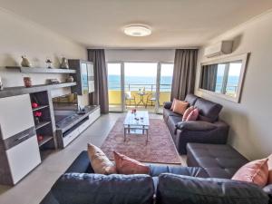 una sala de estar con sofás y vistas al océano. en Apartment Jardins Rose Vista Mar en Portimão