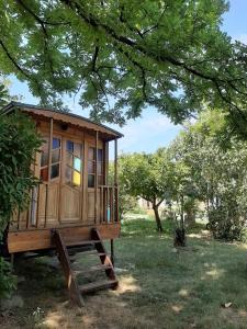 ein Baumhaus in einem Garten unter einem Baum in der Unterkunft Roulotte Marcel Chaix Accueil in Étoile-sur-Rhône