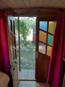 a door to a room with a view of a yard at Roulotte Marcel Chaix Accueil in Étoile-sur-Rhône