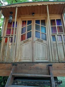 a wooden cabin with glass windows on top of it at Roulotte Marcel Chaix Accueil in Étoile-sur-Rhône