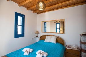 Un dormitorio con una cama azul con toallas. en Mykonos Pro-care Suites, en Ano Mera