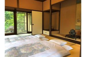 a large bed in a room with windows at Shohakuen in Takayama