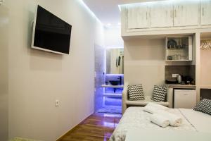 a bedroom with a bed and a television on a wall at Nature's Guesthouse Luxury Nafplio in Nafplio