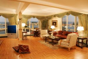Helnan Royal Hotel - Montazah Gardens في الإسكندرية: غرفة معيشة مع أريكة وتلفزيون