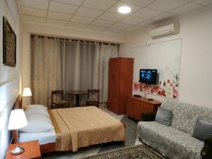 Habitación de hotel con cama y sofá en ApartHotel "Ha-Tzomet", en Bat Yam