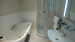 a bathroom with a shower and a tub and a sink at The Swan At Hay in Hay-on-Wye