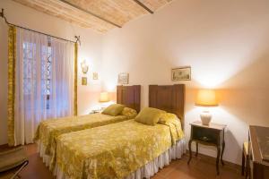 Proceno的住宿－卡斯特羅普羅賽諾酒店，一间卧室设有两张床和窗户。