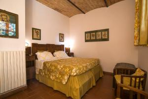 um quarto com uma cama e uma cadeira num quarto em Castello Di Proceno Albergo Diffuso In Dimora D'Epoca em Proceno