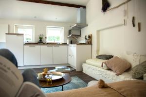 a living room with a couch and a kitchen at Lavender Lodge in Achthuizen