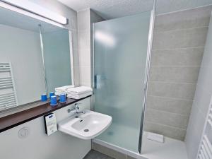 a bathroom with a sink and a shower at Kyriad Lille Est - Hem in Hem +21 photos
