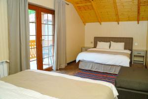 a bedroom with two beds and a couch and a window at CHALET DILIJAN VILLAS in Dilijan