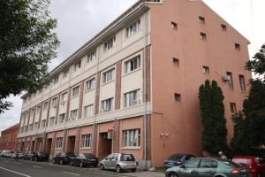 a large brick building with cars parked in front of it at Apartment Brownie in Timişoara