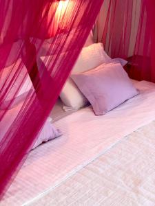 a bed with pink mosquito netting over it at Elena Studios & Apartments in Piso Livadi