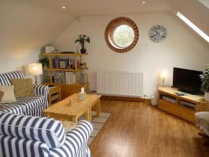 a living room with two couches and a television at The Miners Cottage in Whitecroft