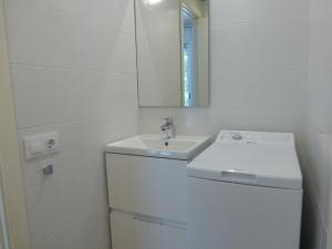 a white bathroom with a sink and a mirror at Rentalmar Delfos Playa in Salou +16 photos