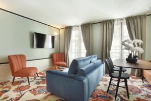 - un salon avec un canapé bleu et une table dans l'établissement Le Ferdinand - Le Marais Serviced Apartments, à Paris