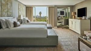 een hotelkamer met 2 bedden en een bureau bij L'Ermitage Beverly Hills in Los Angeles