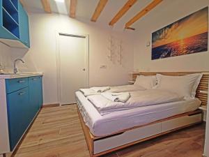 een kleine slaapkamer met een bed en een wastafel bij Ribiška hiša - Old Piran Fisherman's House in Piran