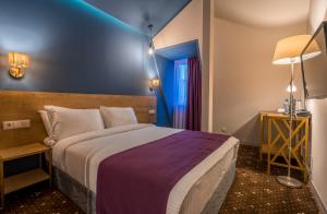 Rúm í herbergi á Gladius Inn Boutique Hotel by DNT Group