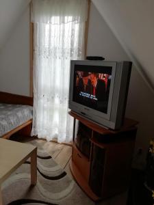 a tv sitting on a stand in front of a window at DOMEK ROZTOCZE in Zwierzyniec +31 photos