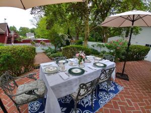 una mesa con un mantel blanco y una sombrilla en Historic Wilson-Guy House en Niagara on the Lake