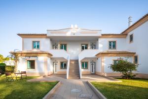 a large white house with a lawn at Epic Falésia Apartment by The Portuguese Butler in Olhos de Água