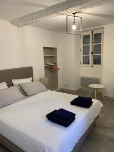 リル・シュル・ラ・ソルギュにあるLES LAURIERSのベッドルーム1室(白い大型ベッド1台、青いタオル2枚付)