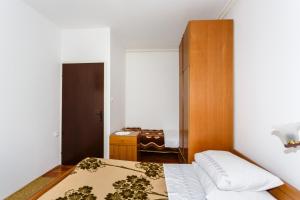 una piccola camera con letto e cassettiera di Apartmani Jelica a Krk