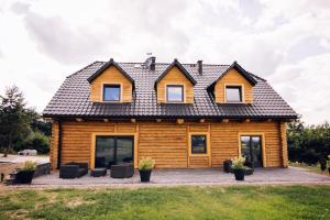 ein Holzhaus mit schwarzem Dach in der Unterkunft Belle Maison in Polanica-Zdrój