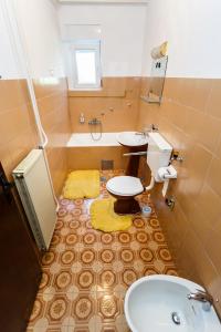 a bathroom with a sink and a toilet and a tub at Apartmani Jelica in Krk