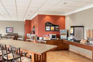 a kitchen with a table, chairs and a refrigerator at Days Inn by Wyndham Montmagny in Montmagny