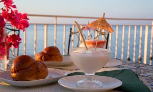 a table with two plates of food and a drink at Appartamento in Villa Agnese in Acitrezza