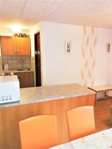 kuchnia z pomarańczowymi krzesłami i blatem w obiekcie APARTMÁN BERAN w Rokitnicach nad Izerą +6 zdjęć
