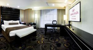 トルーカにあるCrowne Plaza Toluca - Lancaster, an IHG Hotelのベッドとテレビが備わるホテルルームです。
