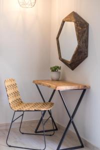 a dressing table with a chair and a mirror at Rarakos Houses Corfu in Corfu Town